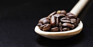 Coffee beans in a wooden spoon 4K