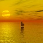 Sailboat Crossing The Sea During A Sunset