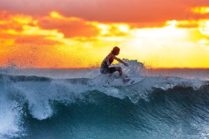 Man Surfing Waves at Sunset