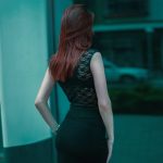 Elegant redhead woman who looks at herself in the mirror